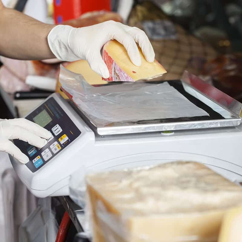 Salesman Weighting Cheese On Weight Scale In Store Food Scale